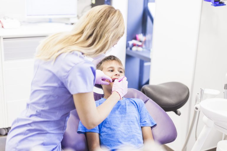 dentist-doing-dental-treatment-boy-clinic